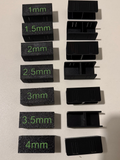 Set of black measurement blocks with green measurements on a beige surface