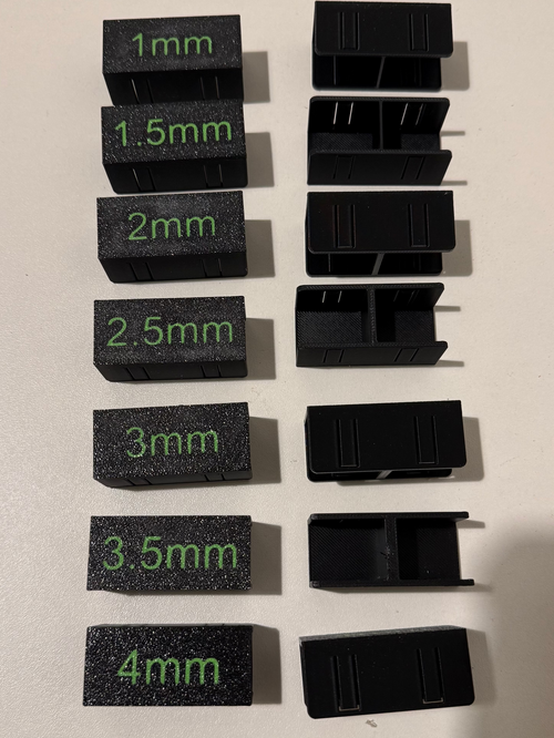 Set of black measurement blocks with green measurements on a beige surface